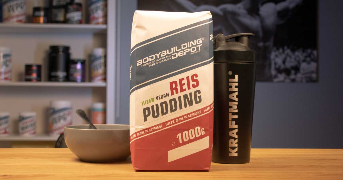 Bodybuilding Depot Reispudding neben Kraftmahl Shaker und Schüssel auf Holztisch