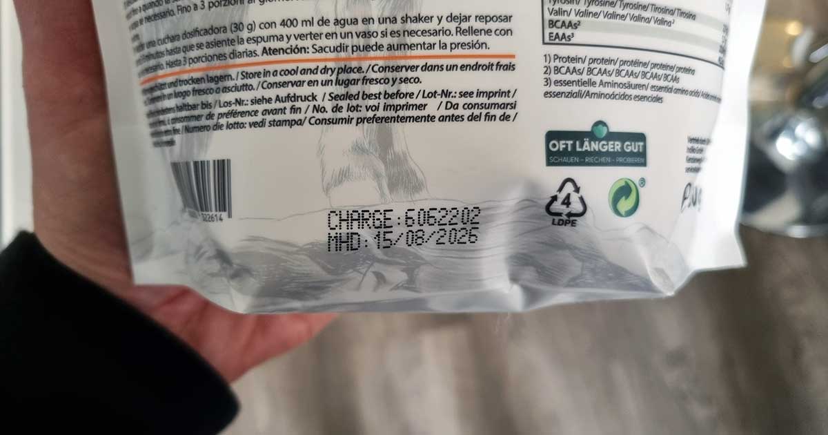 Alpenpower Clear Whey-Tüte in Hand mit Fokus auf Produktionscharke