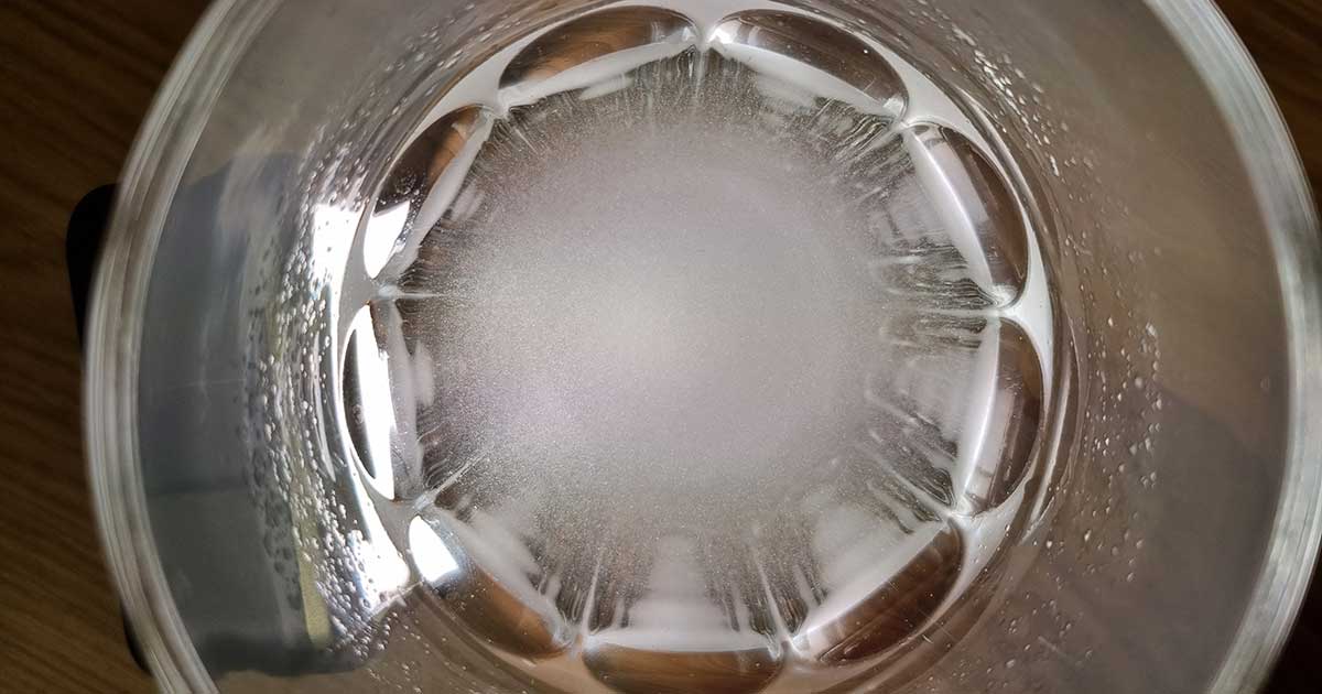 GymBeam Creatine Monohydrate im Löslichkeits- und Lichttest: Das mikronisierte Kreatinpulver verteilt sich sichtbar im Wasser und bildet eine weiße Trübung.