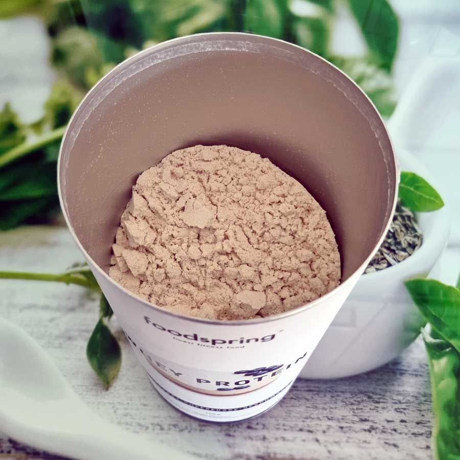 Bild zeigt Dose Foodspring Whey Protein direkt nach dem Öffnen