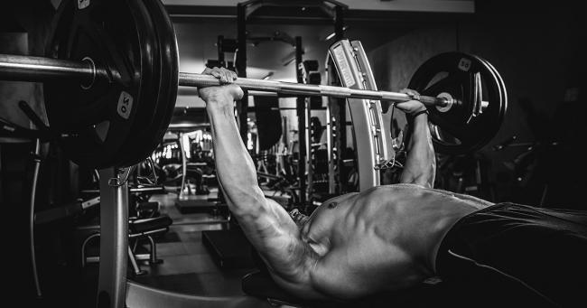 Bild zeigt Sportler beim Bankdrücken von 100 Kilogramm