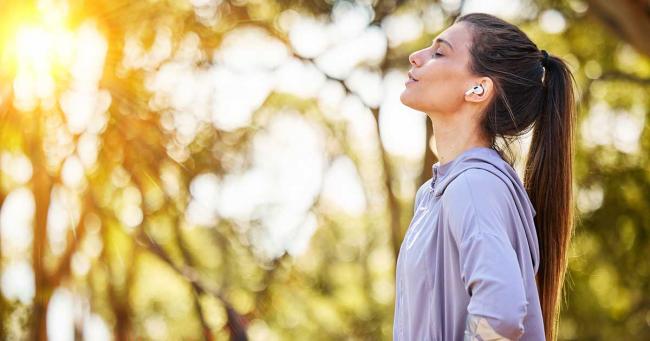 Bild zeigt Frau beim Joggen die tief durchatmet