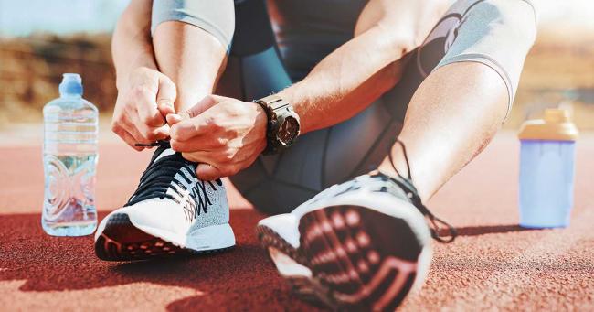 Bild zeigt Sportler mit einer Flasche Wasser