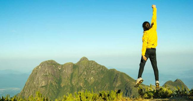 Bild zeigt Sportler, der motiviert in die Luft springt