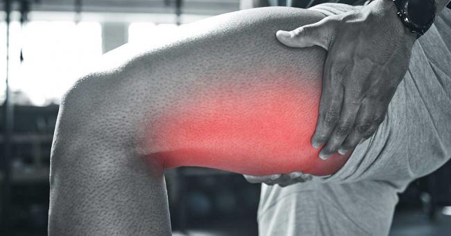 Bild zeigt Sportler mit einem Muskelkrampf im Bein