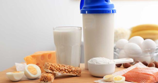 Proteinreiche Lebensmittel, Shake und Proteinpulver stehen zusammen auf Tisch