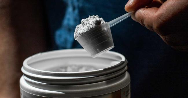 Mann bereitet einen Creatin-Shake vor – Alltagssituation zur Supplement-Einnahme