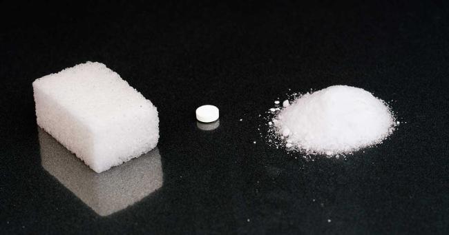 Vergleich von Zuckerwürfel und Süßstoff als kalorienfreie Alternative
