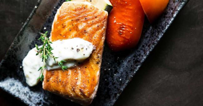 Gebratenes Lachsfilet mit Gemüse als proteinreiche Mahlzeit für Sportler