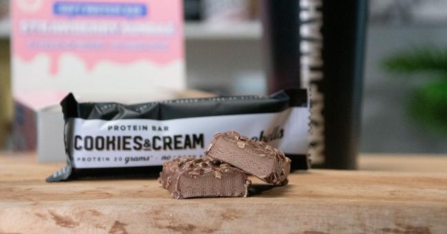 Angeschnittener Barebells Protein Bar Cookies &amp; Cream mit sichtbarer Füllung im Produkttest.
