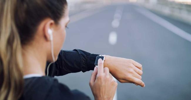 Sportlerin prüft während des Trainings die Daten ihrer Sportuhr