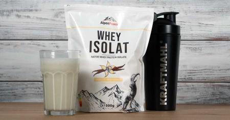 AlpenPower Whey Isolat im Vanille-Geschmack – abgebildet mit Shaker von Kraftmahl und gemixtem Shake im Glas auf Holzuntergrund