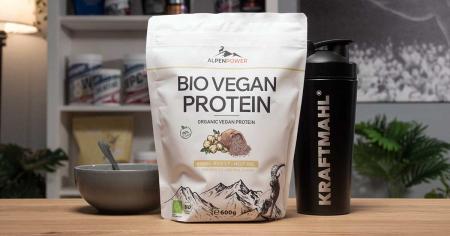 AlpenPower Bio Vegan Protein Erbse Reis im Test – neutrales veganes Proteinpulver mit Shaker und Schüssel auf Tisch