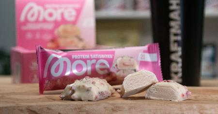 Angeschnittener More Protein Satisbites White Chocolate Strawberry Cream mit cremiger Füllung und weißem Schokoladenüberzug im Produkttest.