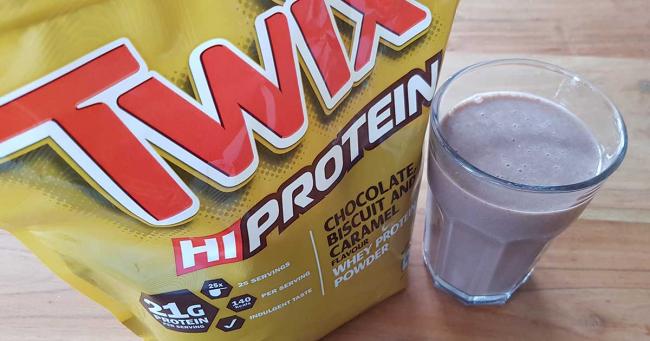 Bild zeigt Twix Protein Pulver mit einem Glas Shake
